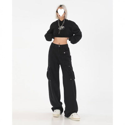 Woman wearing black long-sleeve crop top and black baggy pants.